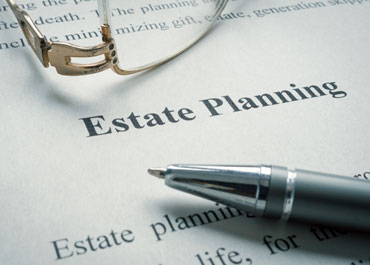 A pen and glasses on top of an estate planning document. - Legacy Law Centers