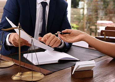 A man and woman in business attire sitting at a desk discussing estate planning insights in Leesburg, VA and Nashville, TN. - Legacy Law Centers