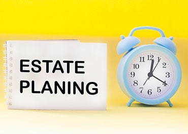 Alarm clock and notebook symbolizing estate planning